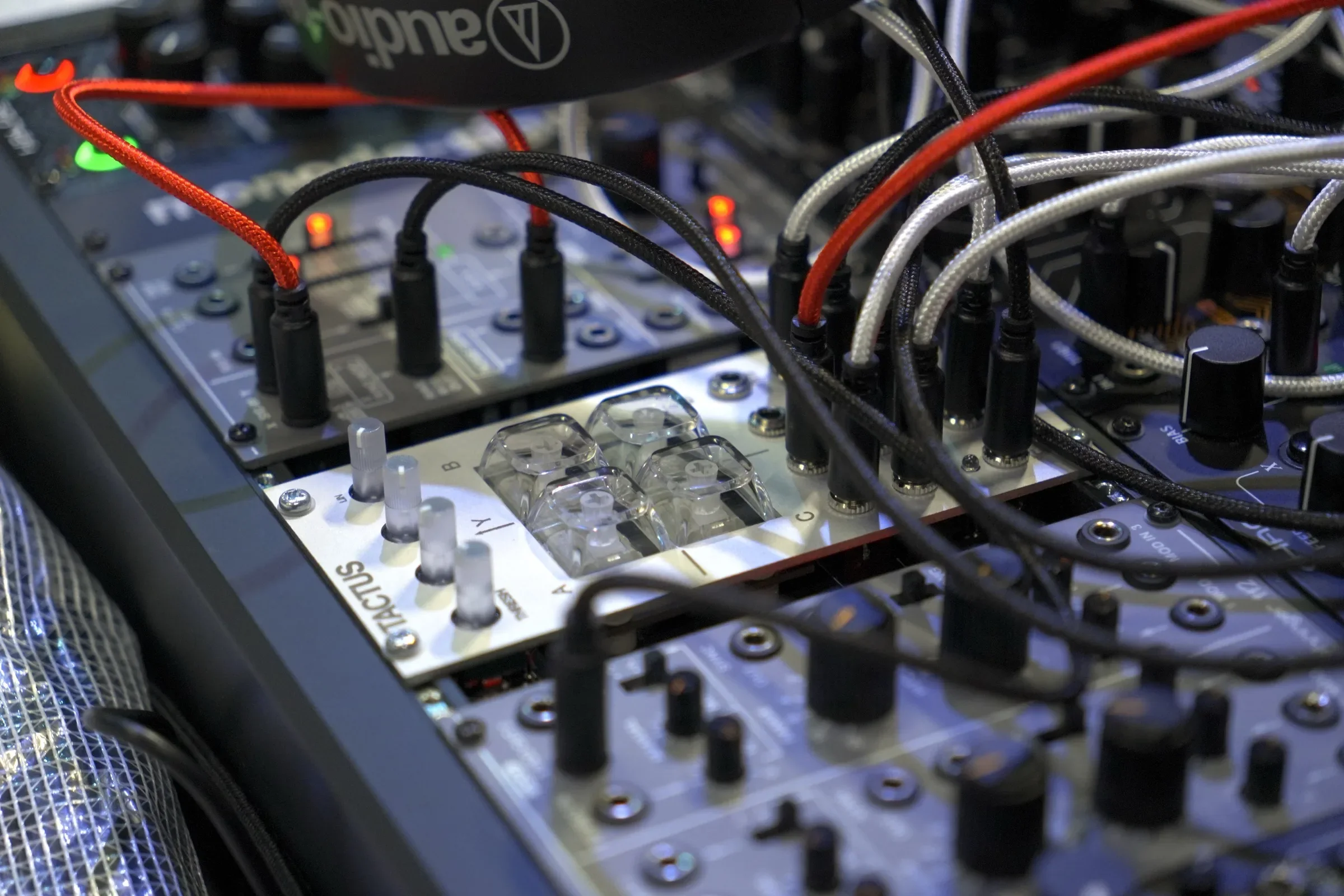 TACTUS mounted in a Eurorack case among other modules, patched with cables